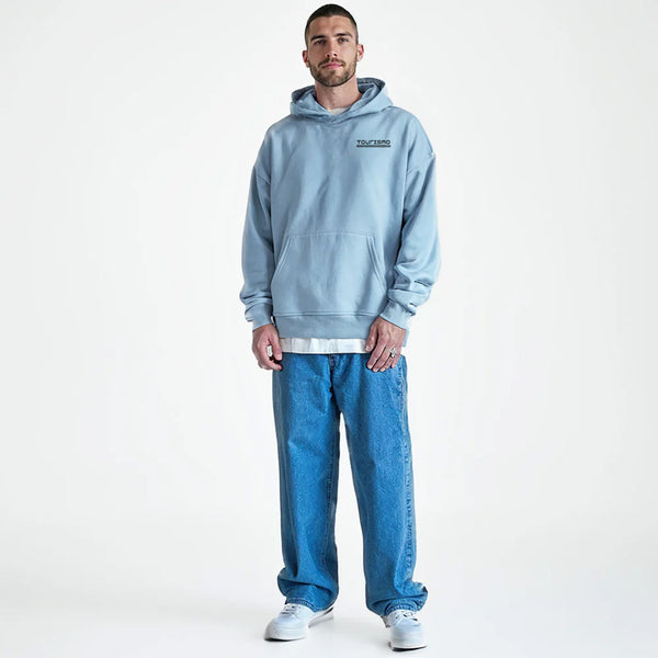 Homme en hoodie bleu clair TOURISMO, jean large et baskets blanches