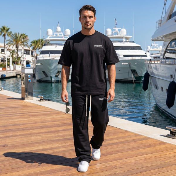 Homme portant le t-shirt noir Concours Circle 300 SL sur un ponton de marina entre yachts