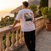 Homme portant le t-shirt blanc Grand Touring Club 911 Turbo sur une terrasse de la côte amalfitaine au lever du soleil