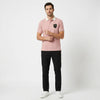 Homme portant le polo Porsche GT3 RS rose, vu de face en pied